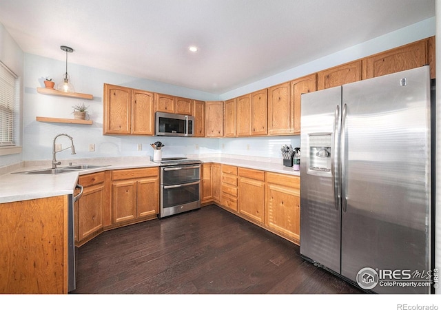 kitchen featuring dark hardwood / wood-style flooring, sink, decorative light fixtures, and appliances with stainless steel finishes