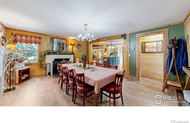 2420 Big Owl Rd, Allenspark, CO 80510 - dining area with light hardwood / wood-style flooring, a notable chandelier, and a fireplace
