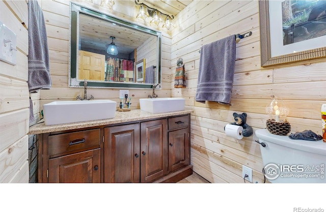 2420 Big Owl Rd, Allenspark, CO 80510 - bathroom with vanity, wooden walls, and toilet
