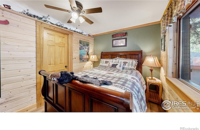 2420 Big Owl Rd, Allenspark, CO 80510 - bedroom featuring crown molding, ceiling fan, and wood walls