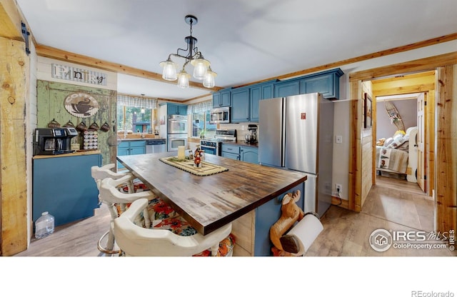 2420 Big Owl Rd, Allenspark, CO 80510 - kitchen with appliances with stainless steel finishes, hanging light fixtures, light hardwood / wood-style floors, blue cabinets, and a chandelier