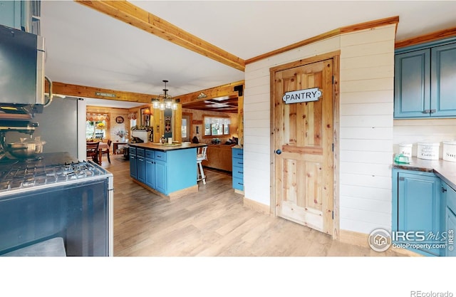 2420 Big Owl Rd, Allenspark, CO 80510 - kitchen with pendant lighting, a breakfast bar area, a center island, blue cabinetry, and beam ceiling