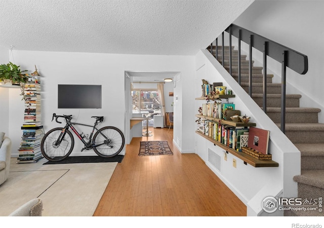 interior space featuring wood-type flooring and a textured ceiling