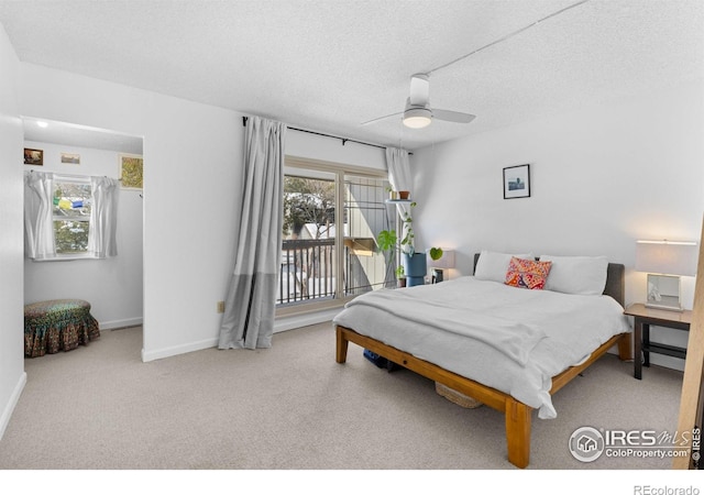 carpeted bedroom featuring access to exterior, a textured ceiling, and ceiling fan