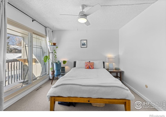 bedroom featuring ceiling fan, carpet flooring, access to exterior, and a textured ceiling