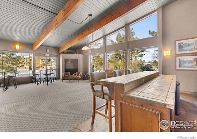 sunroom / solarium featuring plenty of natural light and beamed ceiling