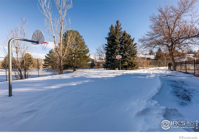 snowy yard featuring basketball court