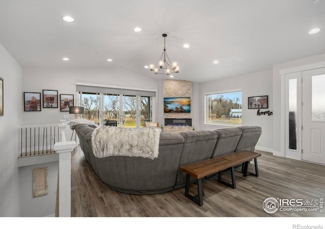 living room featuring lofted ceiling, dark hardwood / wood-style floors, and an inviting chandelier