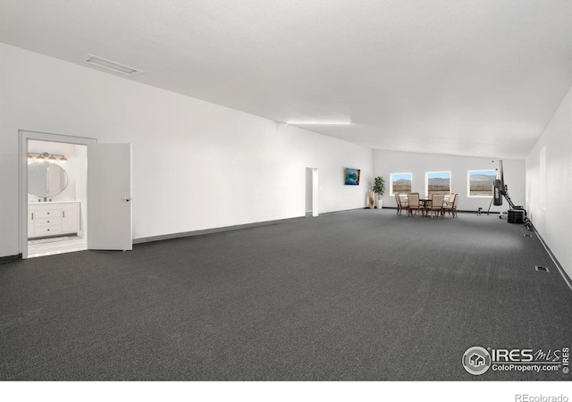 interior space featuring carpet flooring and vaulted ceiling