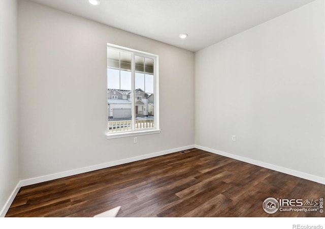 spare room with dark hardwood / wood-style flooring