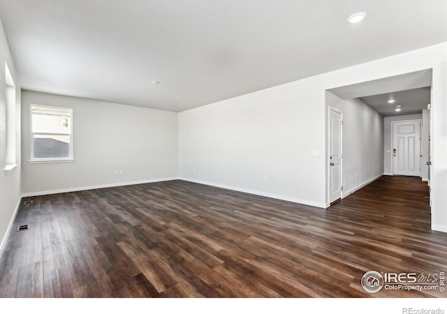 unfurnished room with dark wood-type flooring