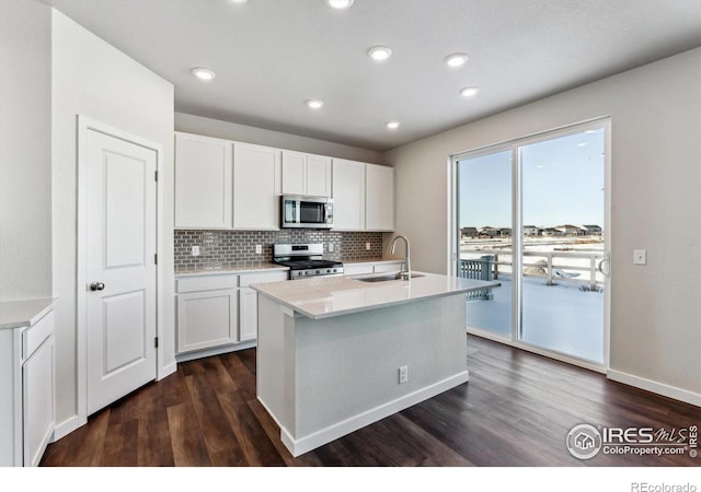 kitchen featuring stainless steel appliances, a kitchen island with sink, sink, and white cabinets