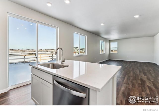 kitchen featuring white cabinetry, dishwasher, sink, an island with sink, and light stone counters