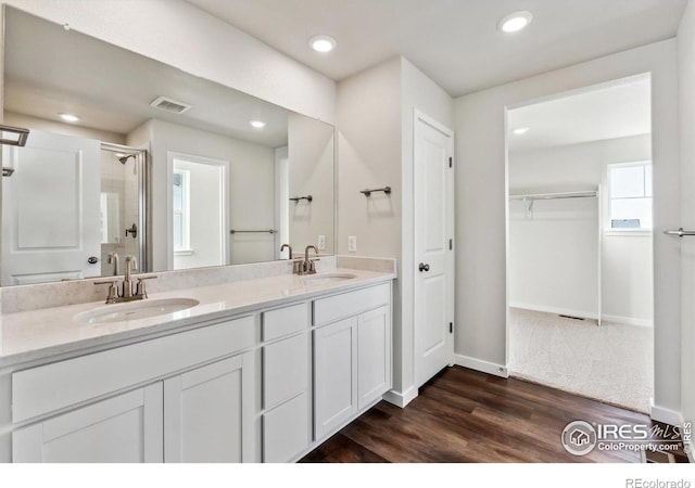 bathroom with hardwood / wood-style flooring, vanity, a shower with shower door, and a wealth of natural light