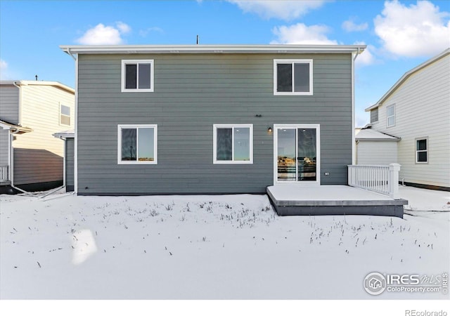 view of snow covered rear of property