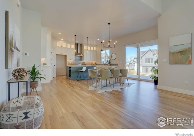 dining space with an inviting chandelier and light hardwood / wood-style flooring