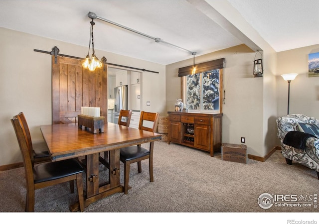 carpeted dining room with a barn door