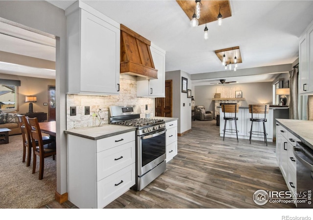 kitchen featuring white cabinetry, stainless steel range with gas cooktop, dishwasher, and backsplash