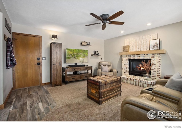 living room featuring ceiling fan and a fireplace