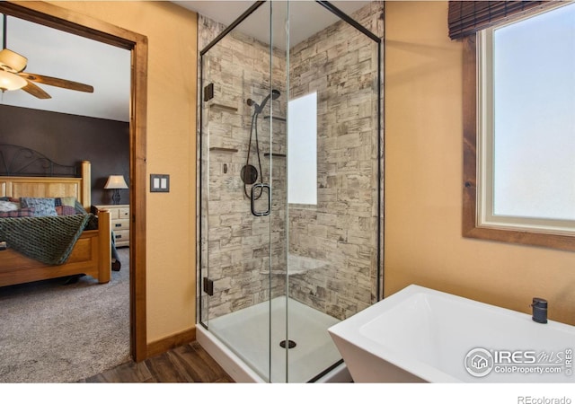 bathroom featuring a shower with door, hardwood / wood-style flooring, sink, and ceiling fan