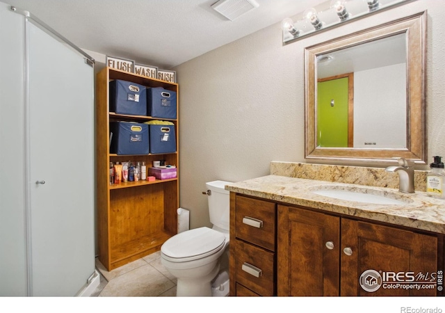 bathroom with tile patterned flooring, vanity, and toilet