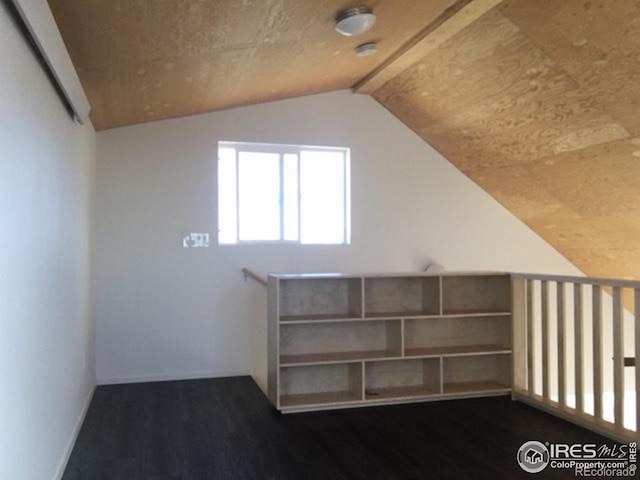 bonus room with dark wood-type flooring and lofted ceiling with beams