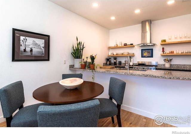 dining room featuring hardwood / wood-style flooring and wet bar