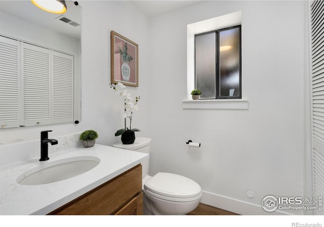 bathroom with vanity, hardwood / wood-style floors, and toilet