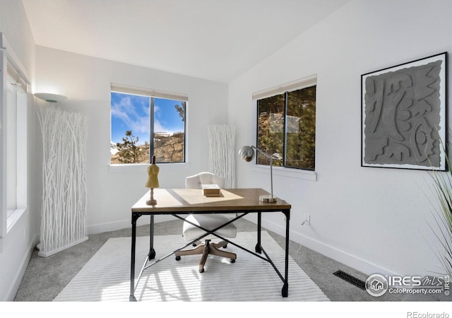 office space featuring light carpet and vaulted ceiling