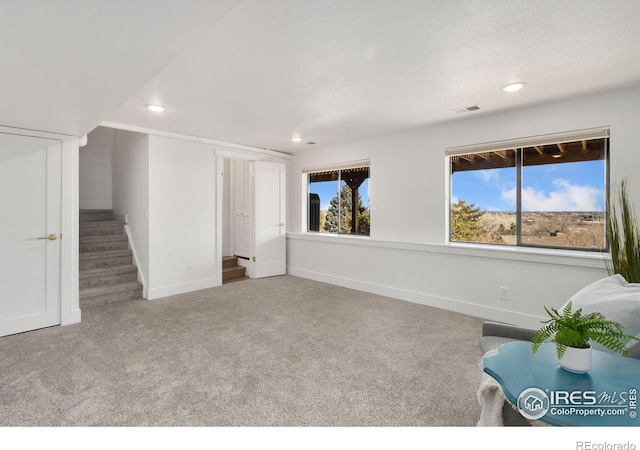 unfurnished room featuring a wealth of natural light and carpet floors