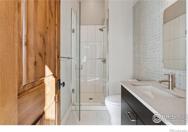 bathroom featuring vanity, toilet, tile patterned flooring, and a shower with door