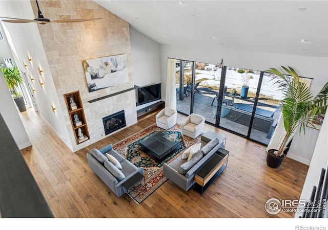 living room with lofted ceiling, hardwood / wood-style floors, plenty of natural light, and a tile fireplace