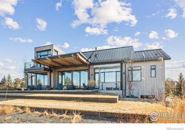 rear view of house featuring metal roof and a standing seam roof