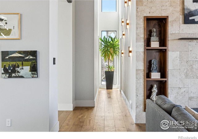 corridor featuring baseboards and hardwood / wood-style floors