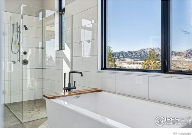 full bathroom with a bathtub, a mountain view, and tiled shower