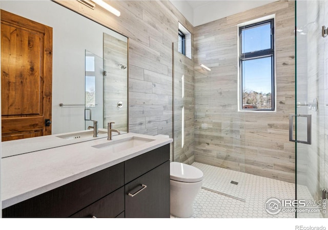 full bath featuring a stall shower, vanity, and toilet