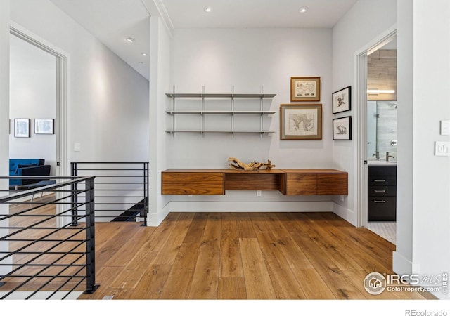 mudroom featuring wood-type flooring, baseboards, a sink, and recessed lighting