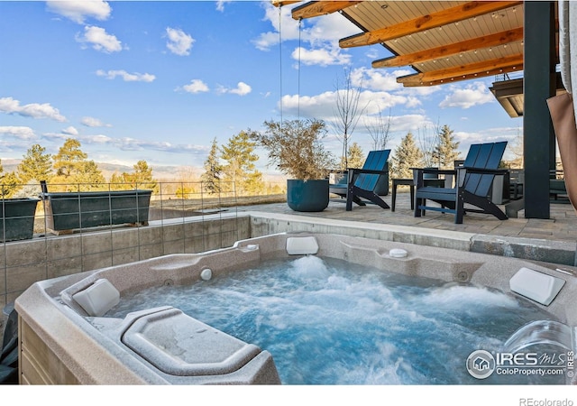 view of patio / terrace with fence and a hot tub