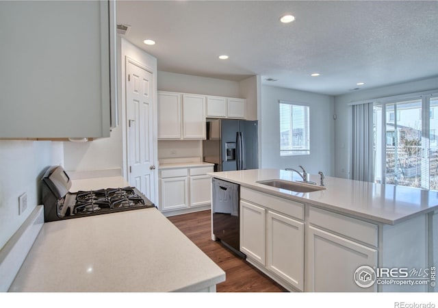 kitchen featuring dark wood-style floors, light countertops, white cabinetry, a sink, and black appliances