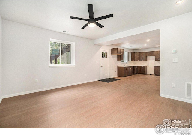 unfurnished living room with light hardwood / wood-style floors and ceiling fan