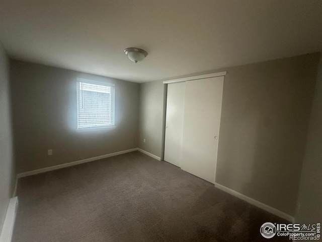 unfurnished bedroom with a closet and carpet flooring