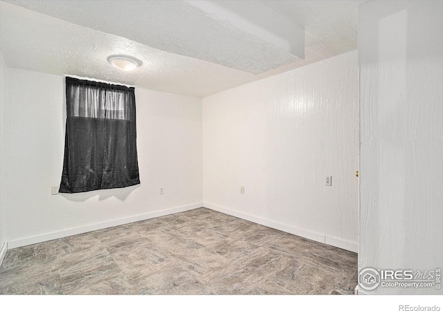 unfurnished room with a textured ceiling