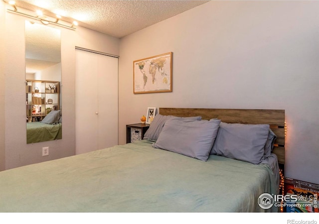 bedroom with a textured ceiling and a closet