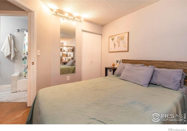 bedroom featuring hardwood / wood-style floors, a closet, and a textured ceiling