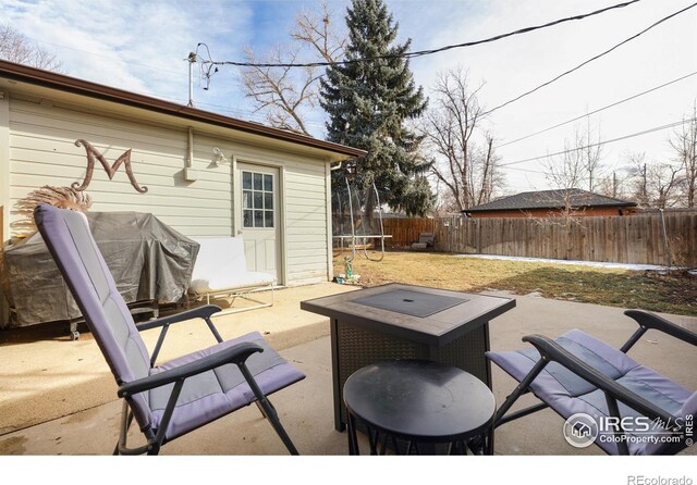 view of patio / terrace featuring a trampoline, a fenced backyard, and grilling area