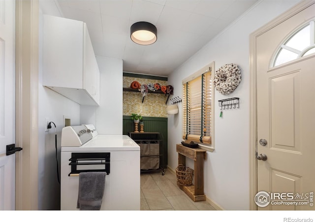 laundry room featuring washer and clothes dryer, cabinet space, and baseboards