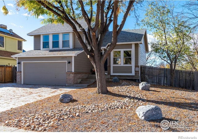 view of front of house featuring brick siding, driveway, a garage, and fence