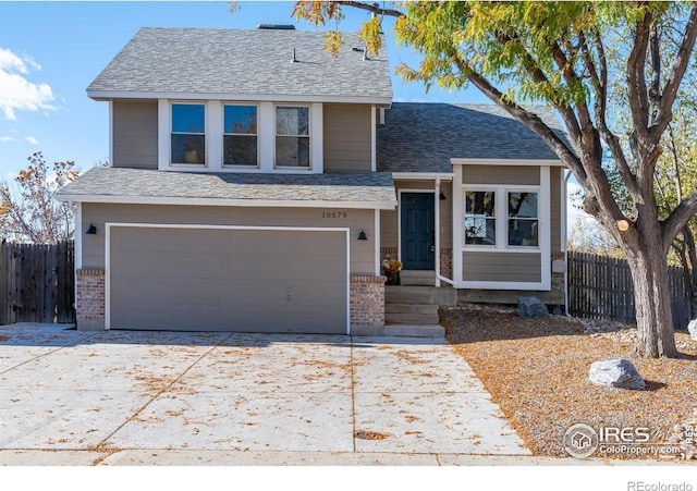 view of front of house featuring driveway, fence, a shingled roof, a garage, and brick siding