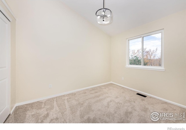 unfurnished room featuring visible vents, baseboards, lofted ceiling, and carpet floors