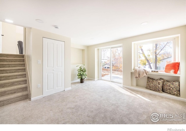 living area featuring stairway, baseboards, and carpet